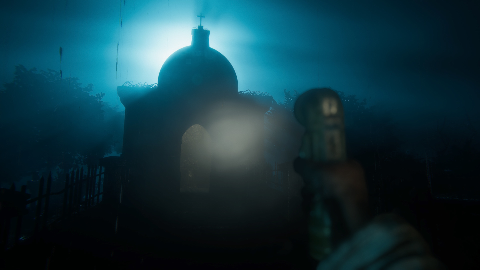A domed chapel silhouetted against cold blue fog